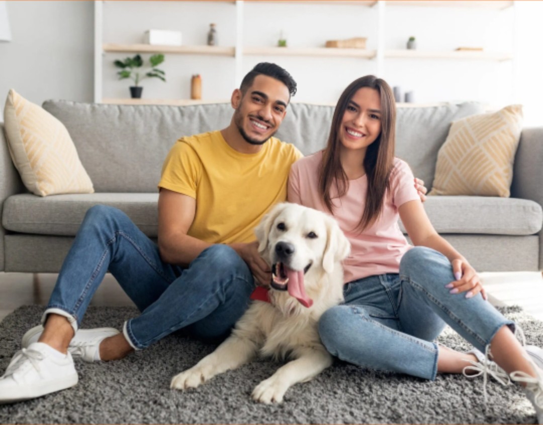 Happy couple with their dog in a new home
